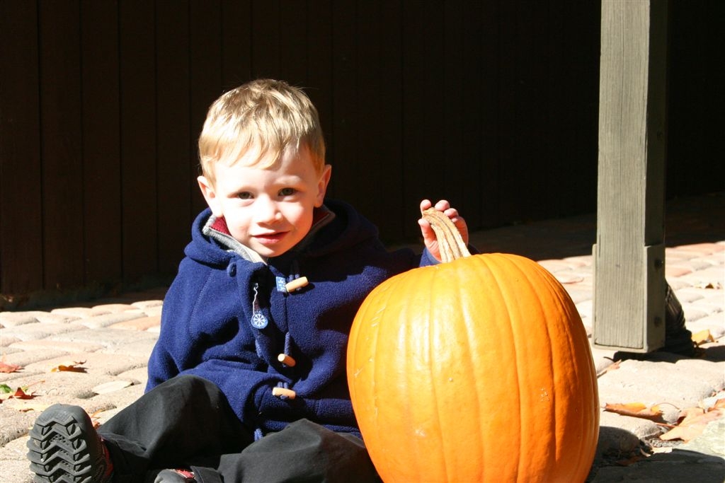 Nate sitting beside a large pumpkin